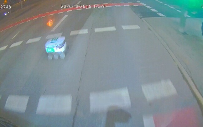 Pakirobot sõitmas punase tulega ette bussile.