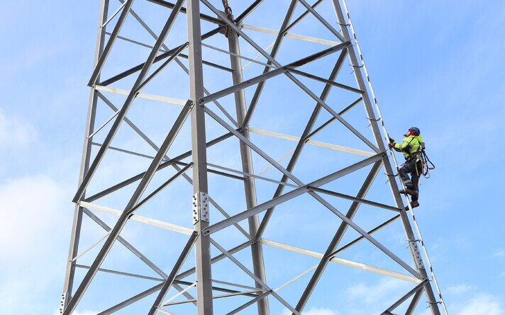 An electrical engineer scaling a pylon.