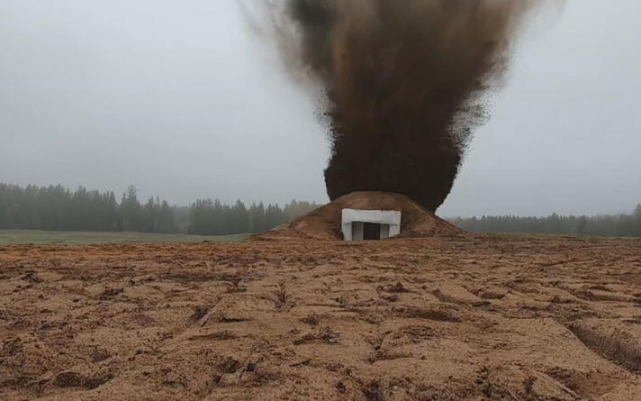 One of the prototype concrete bunkers being subjected to a blast test, via artillery fire.