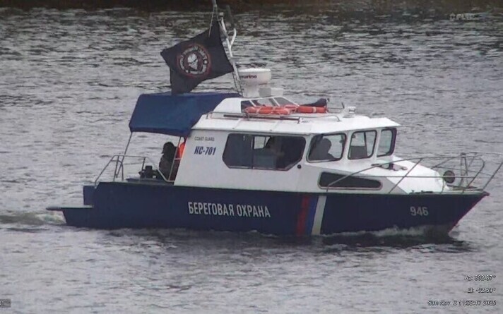 Russian border guard vessel displaying a Wagner Group flag while traveling along the Narva River, which marks the border between Russia and Estonia.