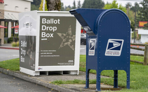 USA postiteenistuse postkast ja selle k&otilde;rval kirja teel saadetud h&auml;&auml;letussedelite kast.