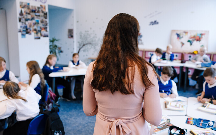 Teacher in front of a classroom full of kids. Photo is illustrative.