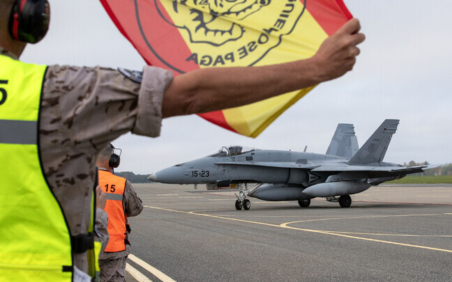 A flag with the Wing 15 patch and the Spanish national colors as the pilots make ready to leave.