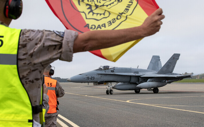 A flag with the Wing 15 patch and the Spanish national colors as the pilots make ready to leave.