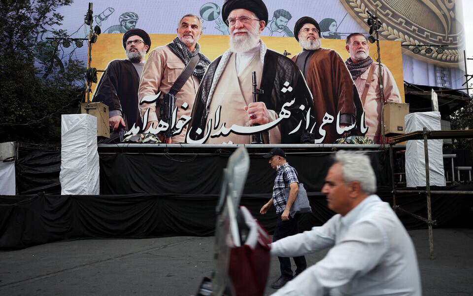Mees m&ouml;&ouml;dub Teheranis plakatist, millel on kujutatud Iraani endist k&otilde;rgeimat juhti Ali Khameneid, Hezbollah&rsquo; endist juhti Hassan Nasrallah&rsquo;d ja kindral Qassem Soleimanit
